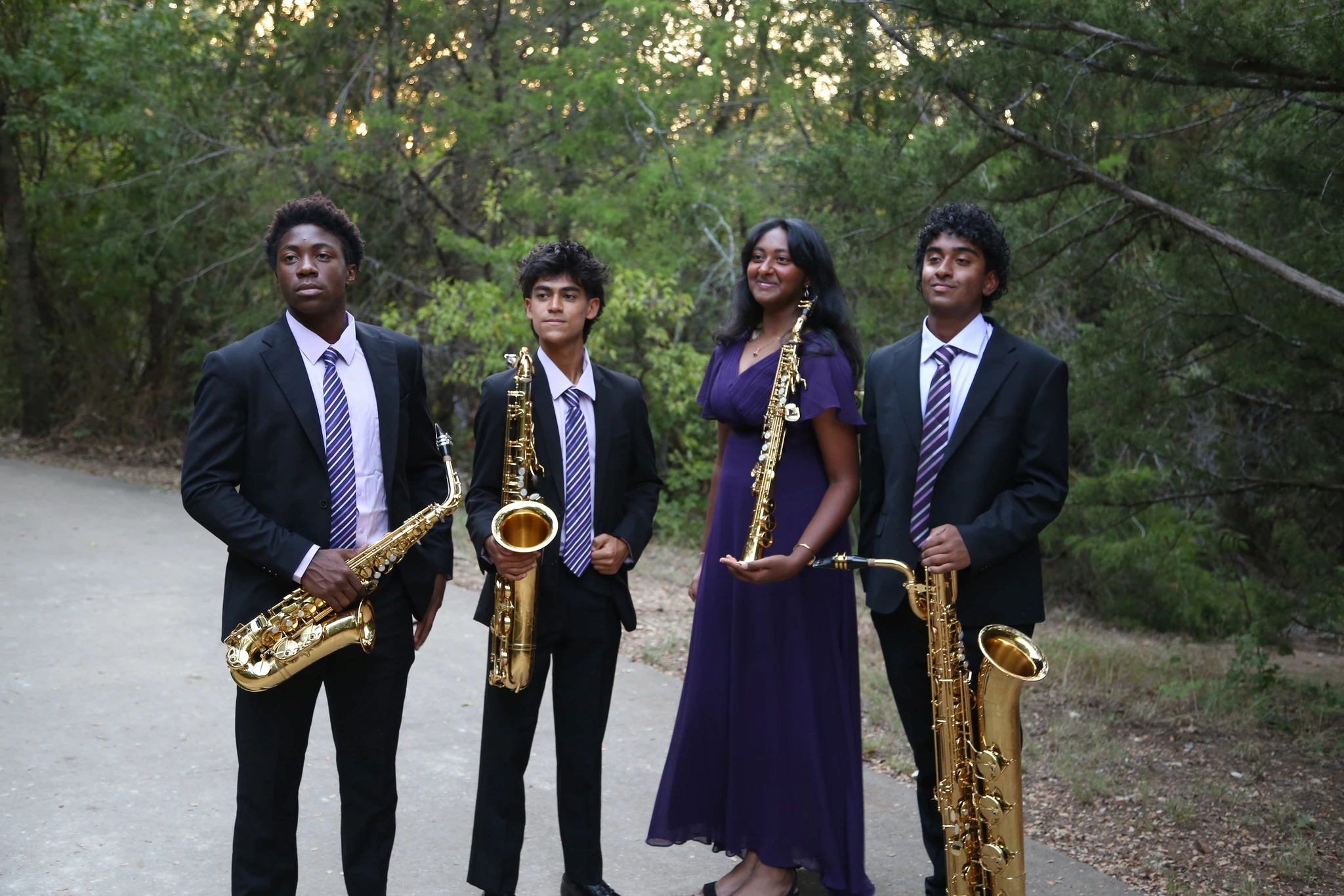 Orion Quartet with their saxophones on a woodland path